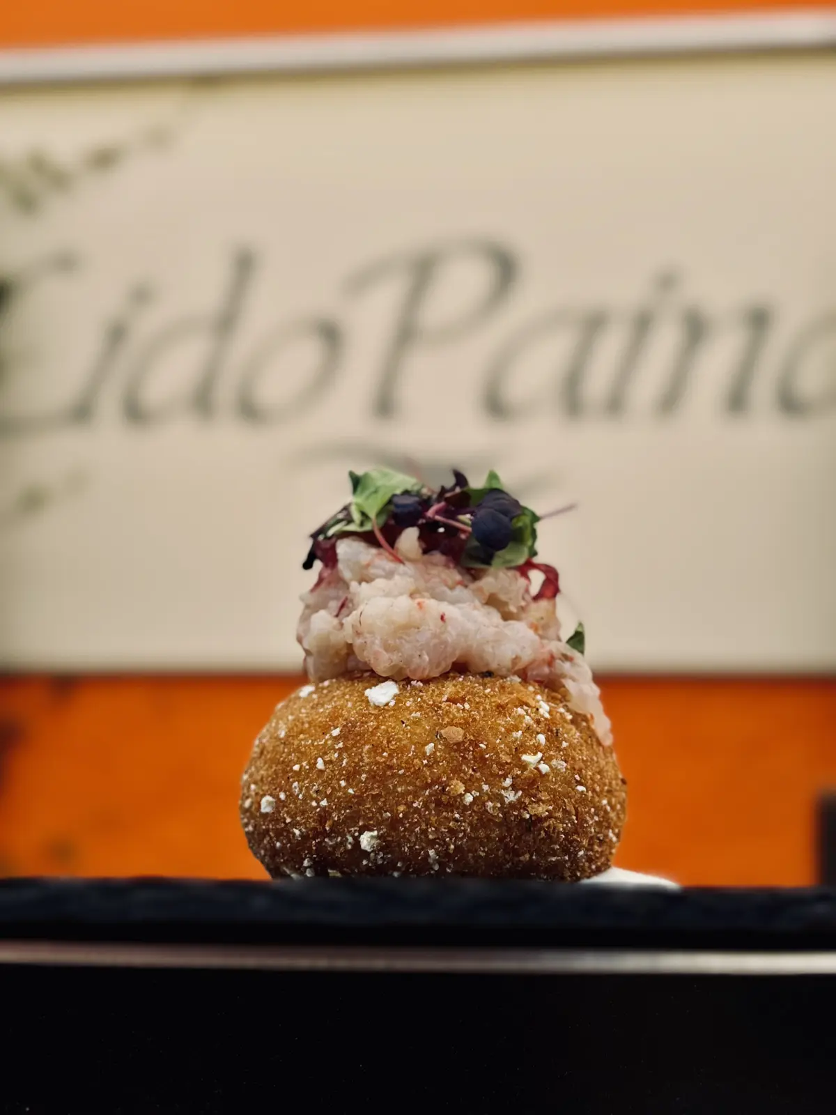 Crocchetta con tartare di gambero davanti all'insegna del Lido Paina